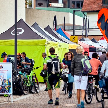 Row of 4x4 m black and lime tents with Ergon logo side walls at the Brixen Bike Festival