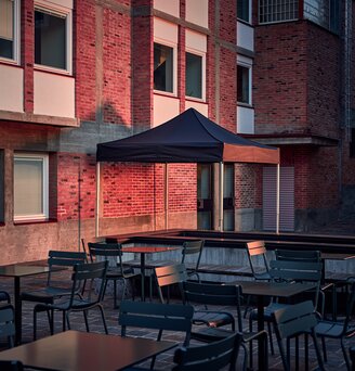 The black 3x3 m folding gazebo serves as an outdoor shelter on the terrace.