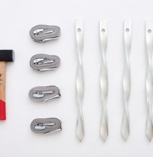 Fastening kit set of 4 consisting of 1 hammer, 4 tension straps and 4 pegs.